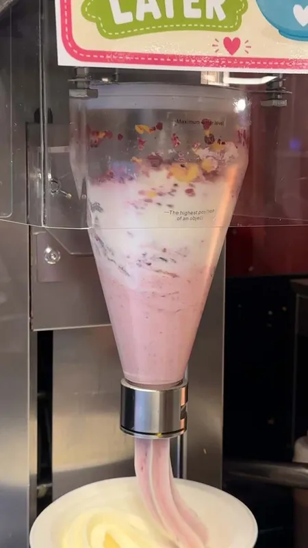 Strawberry soft serve swirling from the machine